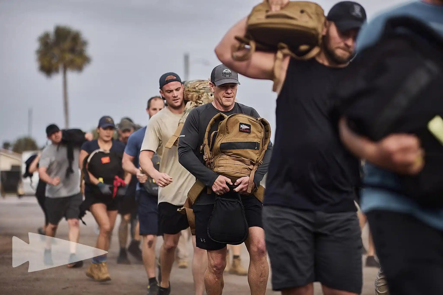 Group rucking outdoors in GORUCK gear, people carrying weighted backpacks in athletic event