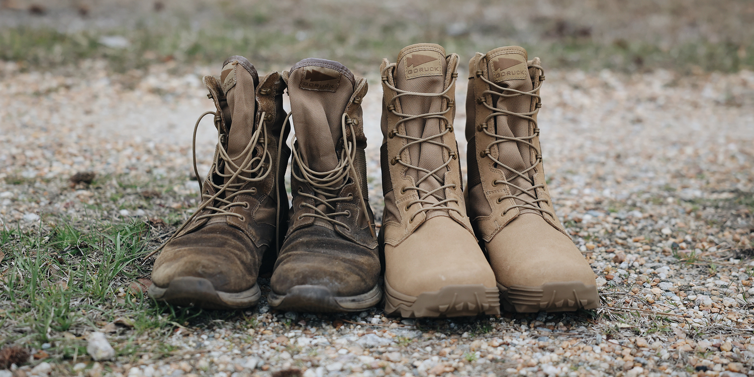 Pair of worn brown and new tan tactical boots standing side by side on gravel ground