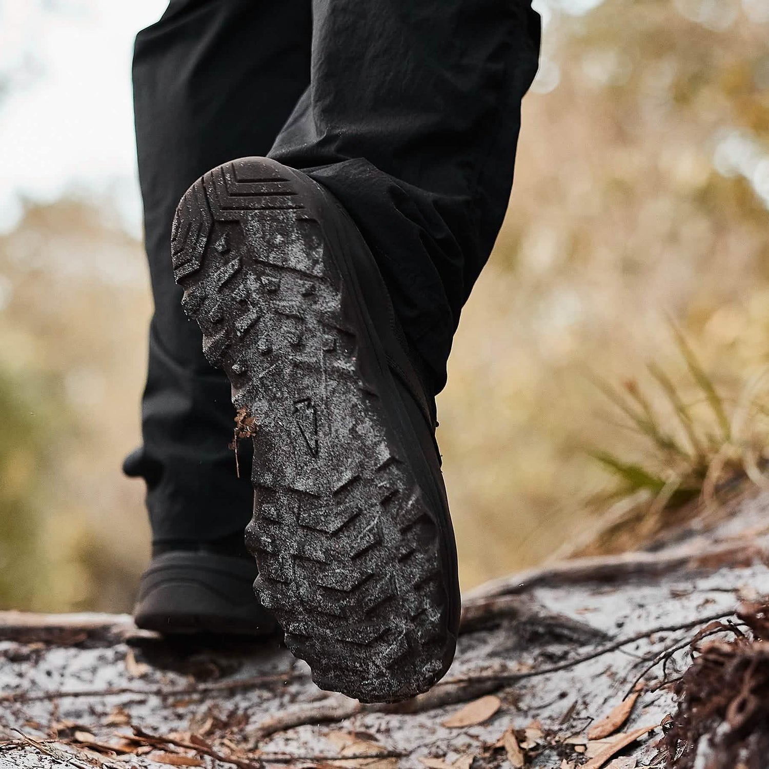 Close-up of a sturdy GORUCK hiking boot sole stepping on a muddy outdoor trail