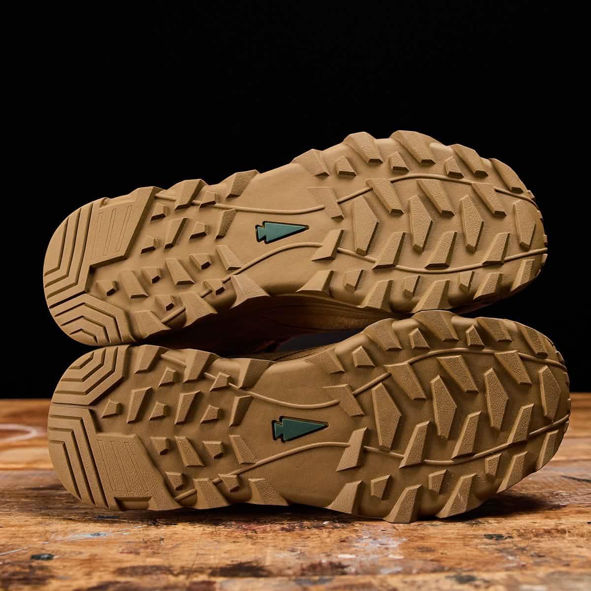 GORUCK rucking shoe soles with rugged tread and arrowhead logo on wooden surface