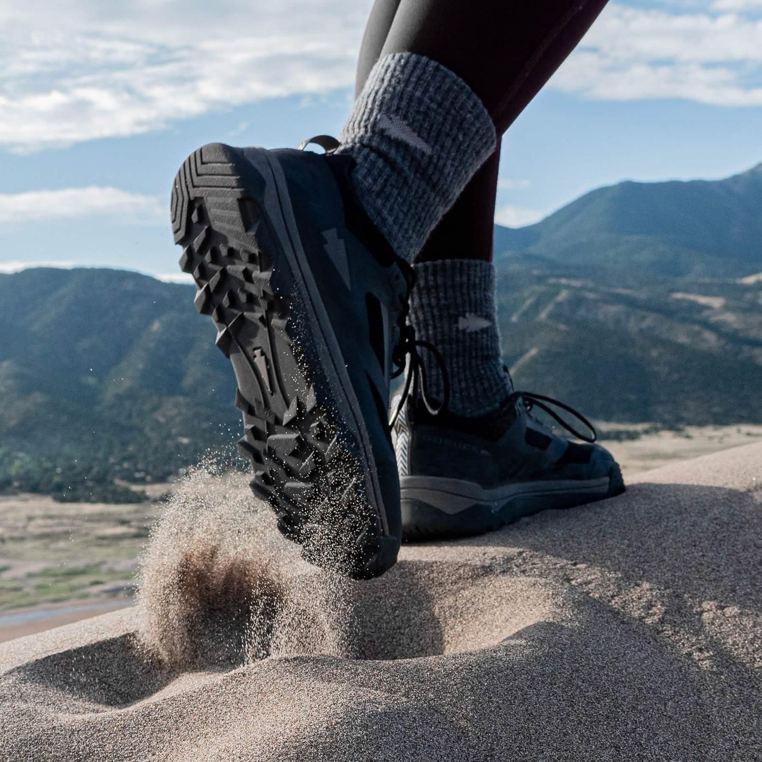 GORUCK rucking shoe kicking up sand on a mountain trail, rugged outdoor adventure gear