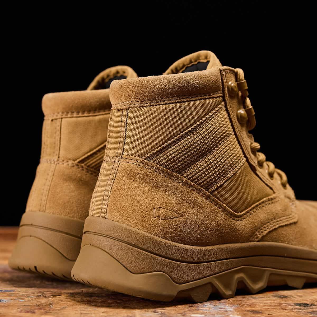 GORUCK tan rucking boots with rugged outsoles on wooden surface, close-up