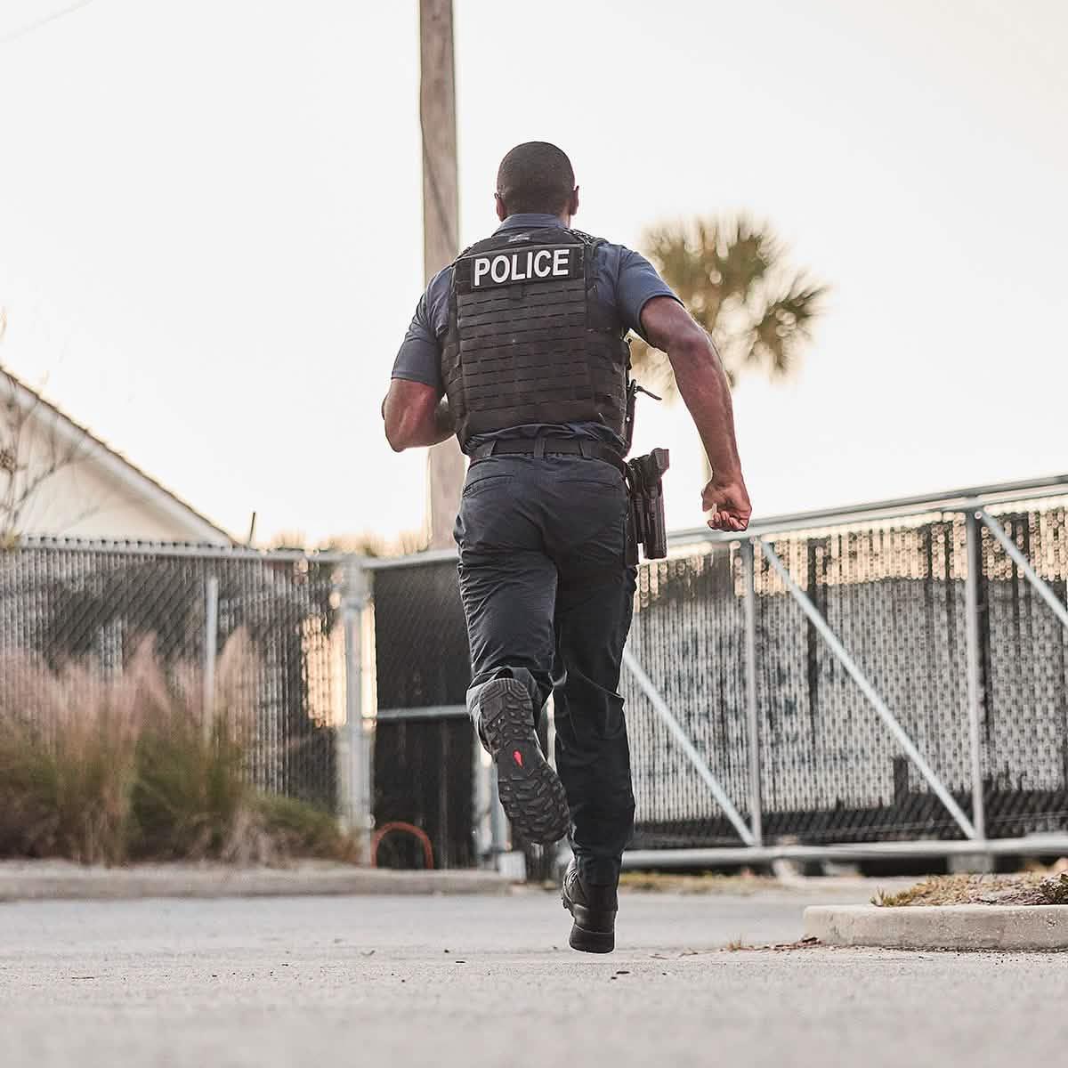 Police officer running outdoors in tactical gear, showcasing GORUCK rucking equipment