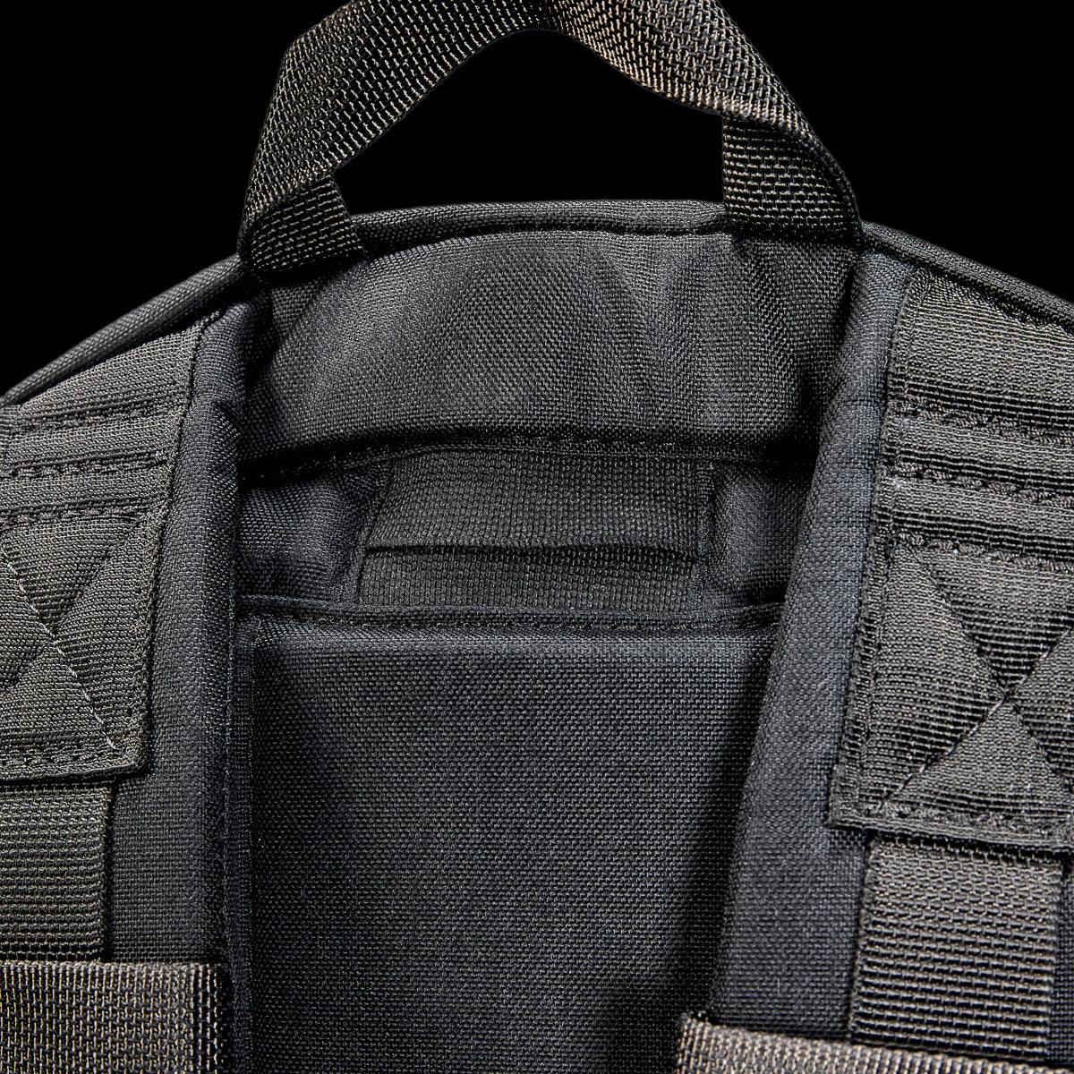 Close-up of black goruck backpack shoulder straps and sturdy carry handle with reinforced stitching