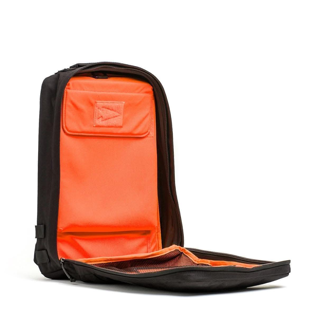GORUCK 15L backpack open, showing orange interior with storage pockets for rucking gear