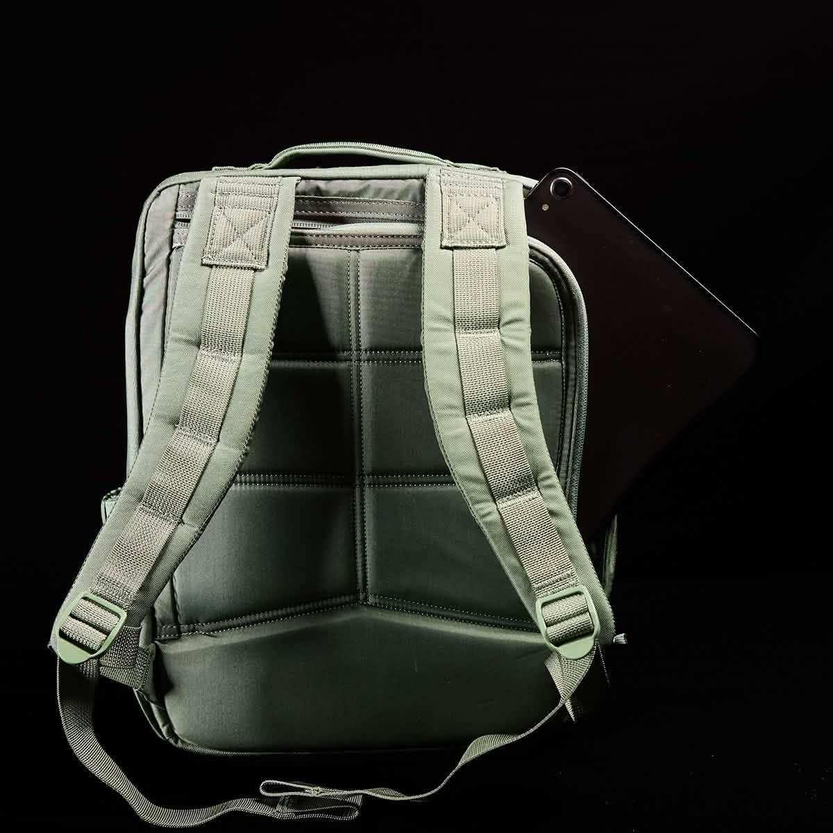 GORUCK tactical green rucksack with padded straps and a black tablet partially inserted