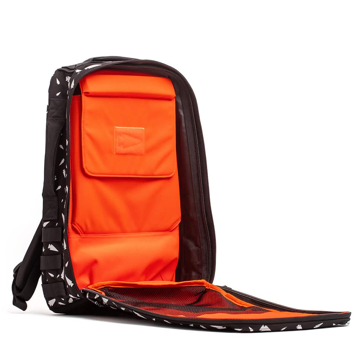 The Rucker 4.0 - Reflective Spearhead is a black rucksack with white shapes, featuring a bright orange interior and mesh pockets—ideal for training or rucking adventures.