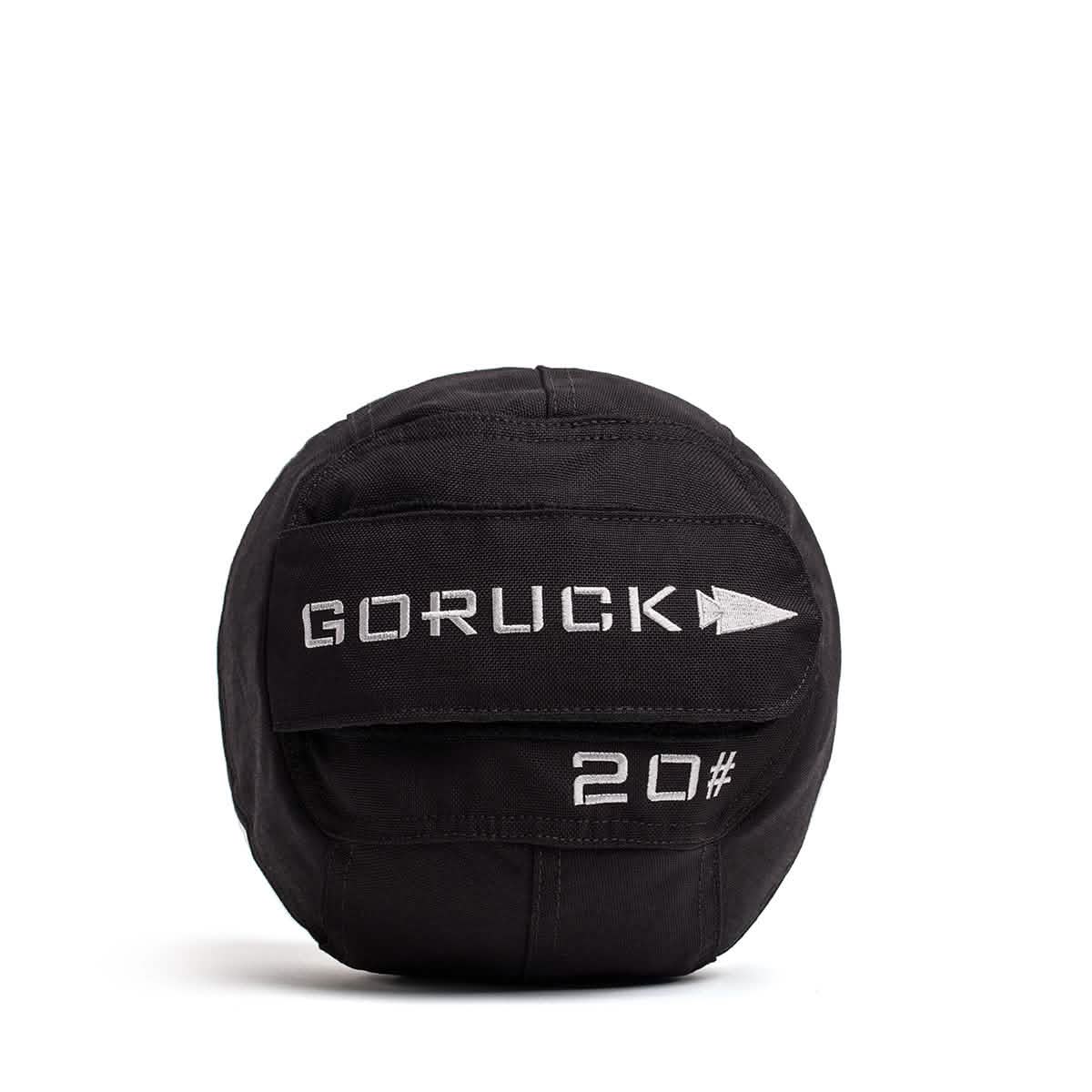 The Sand Medicine Ball in black, adorned with the GORUCK logo and a 20# weight marking, is ideal for boosting core stability. Tailored for fitness training in your home gym, it boasts reinforced stitching and a rugged texture, with the ball displayed against a white background.
