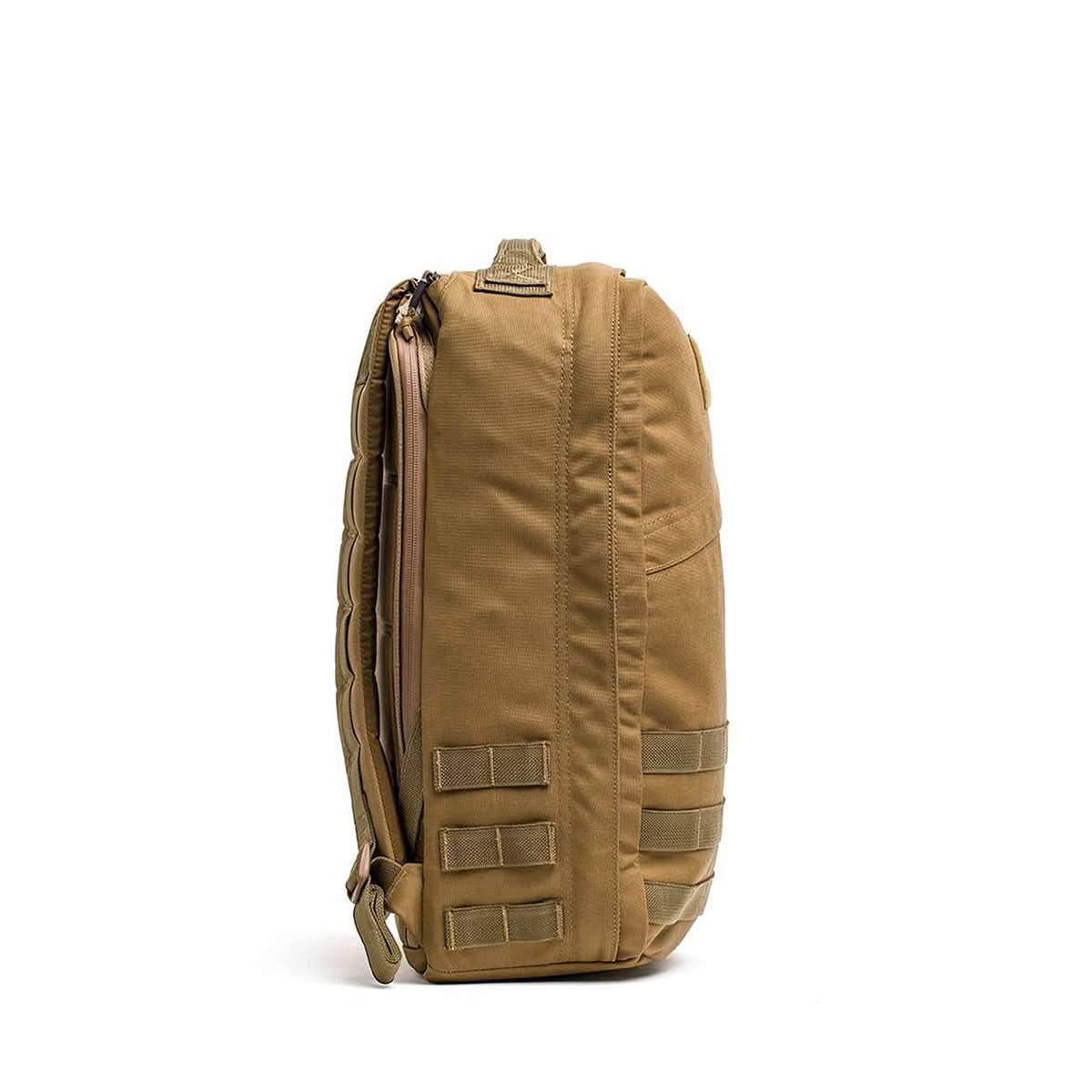 Side view of a coyote brown tactical rucksack with MOLLE webbing and padded shoulder strap