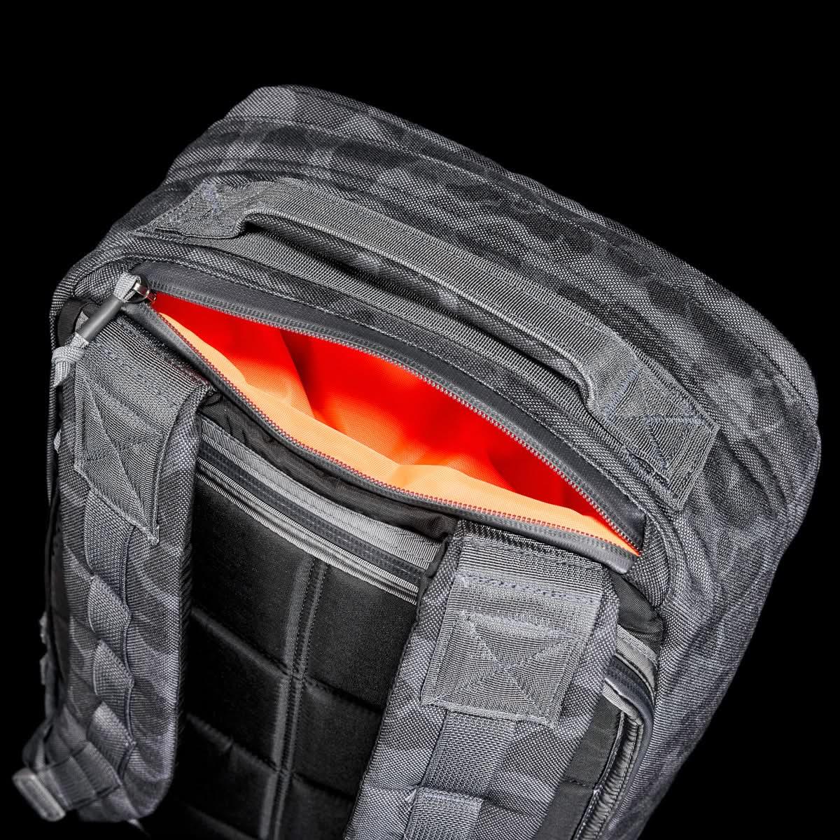 Close-up of GORUCK Frogskin backpack in black with padded straps and bright red interior lining