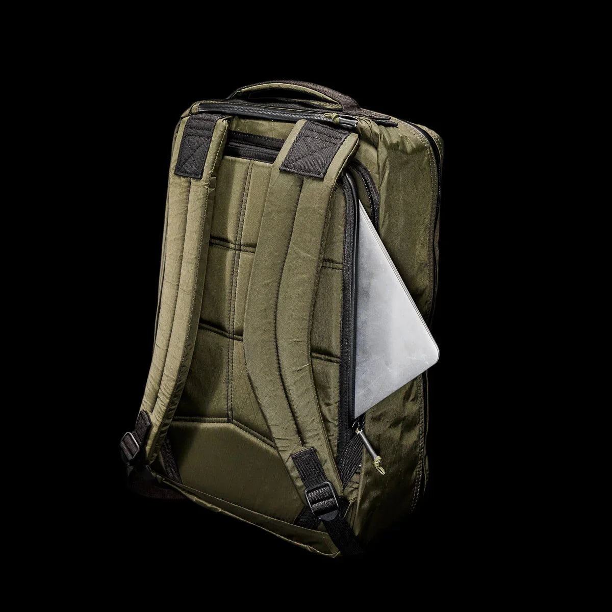 GORUCK dark green tactical rucksack with padded straps and partially open laptop compartment on black background