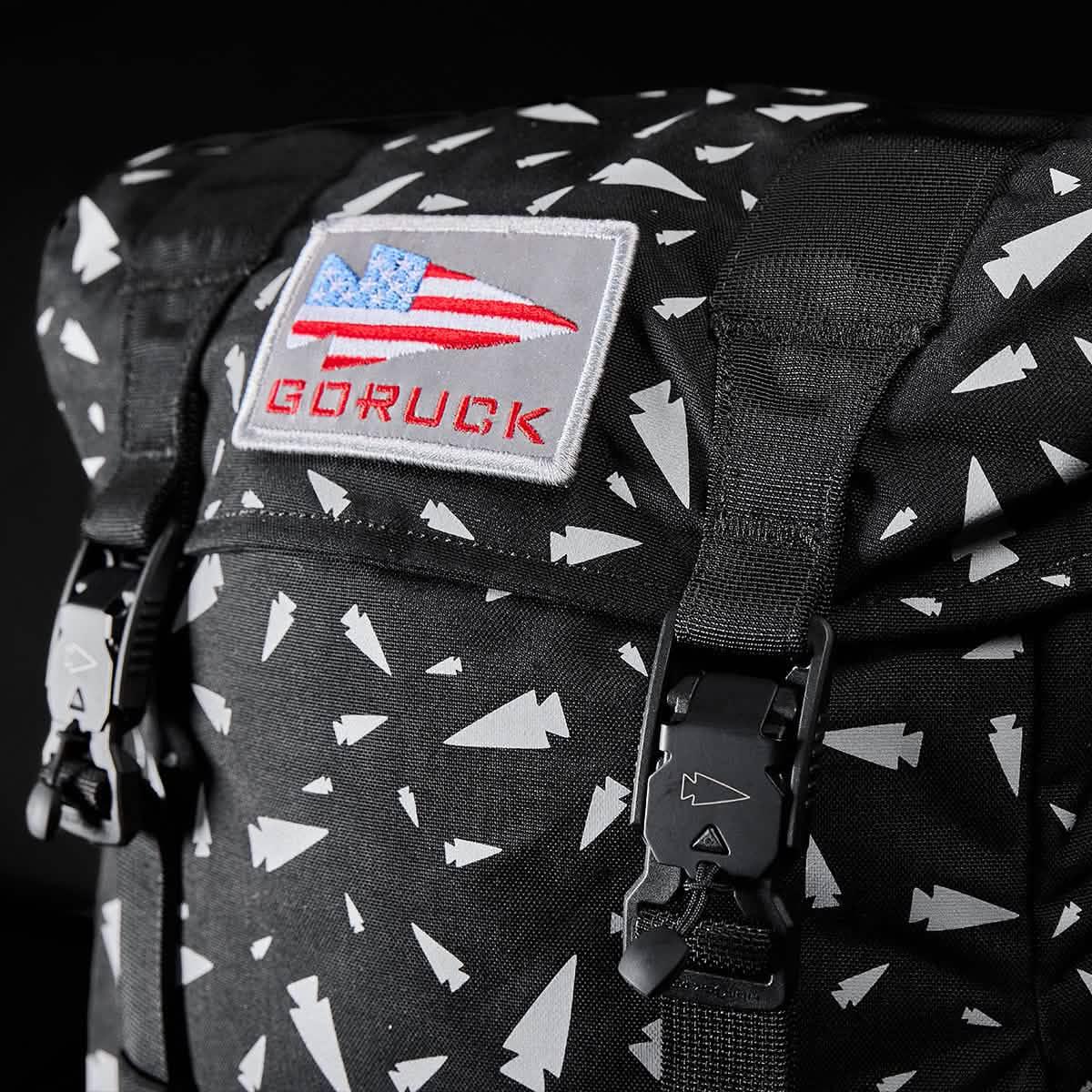 Close-up of a black M23 - Ballistic Nylon Cordura rucksack with white geometric shapes and a GORUCK US flag patch—designed for durable everyday carry.