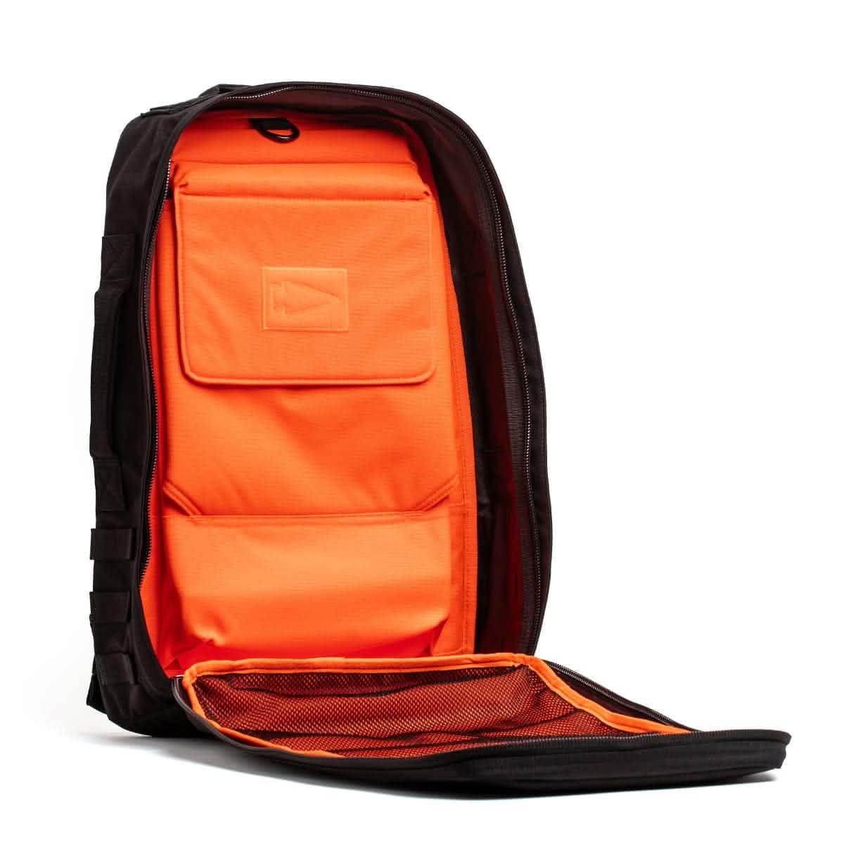 GORUCK 25L rucksack open to show bright orange interior, black exterior, and front mesh pocket