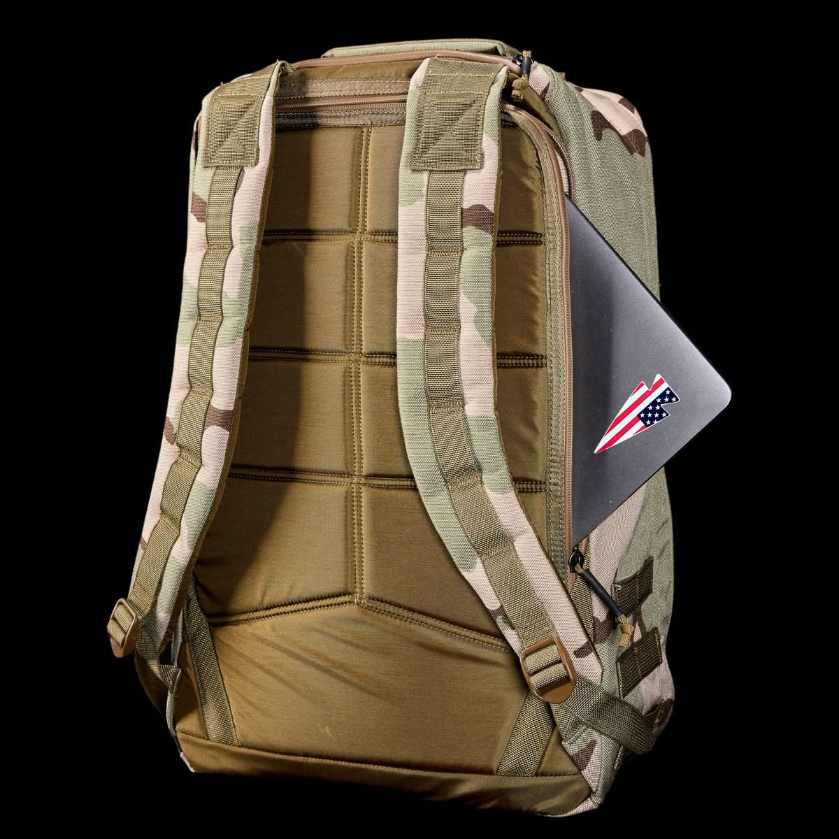 GR1 USA - Ballistic Nylon Cordura (The Original Ruck) with 210D back panel, padded straps, and a laptop peeking from the side pocket—an everyday carry pack inspired by Special Forces, shown on a black background.