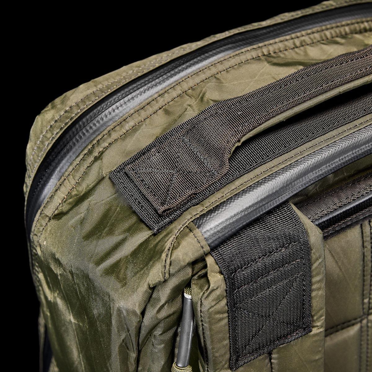 Close-up of rugged dark green GORUCK rucking bag corner with heavy-duty handle and weather-resistant zipper