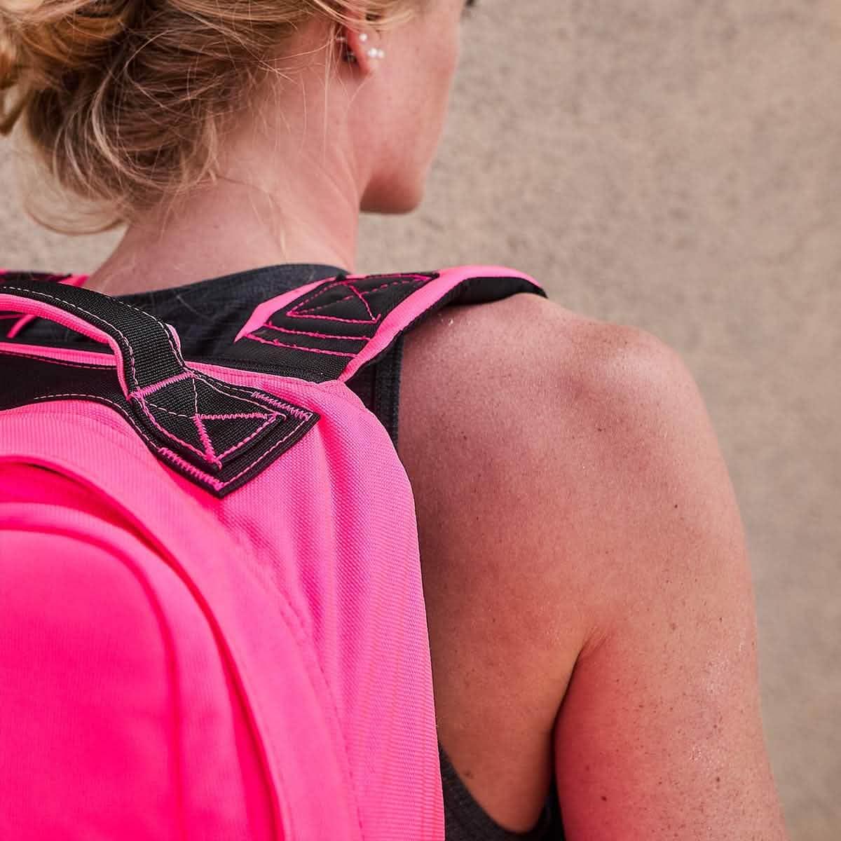 Woman wearing a hot pink GORUCK rucksack on shoulder, close-up of backpack straps and skin