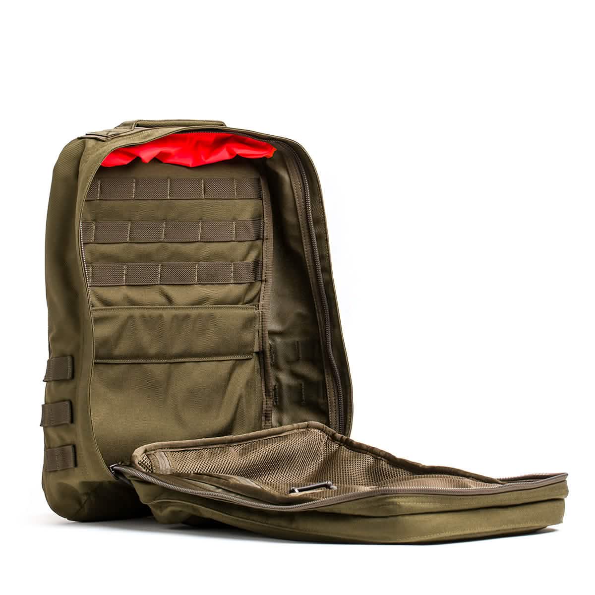 The GR2 - Cordura from GORUCK is a tactical backpack designed for Special Forces, featuring a zippered front that opens up to multiple compartments and mesh pockets. The interior showcases a bright red lining, and its design incorporates MOLLE webbing to attach extra gear—an authentic ruck that captures the essence of adventure.