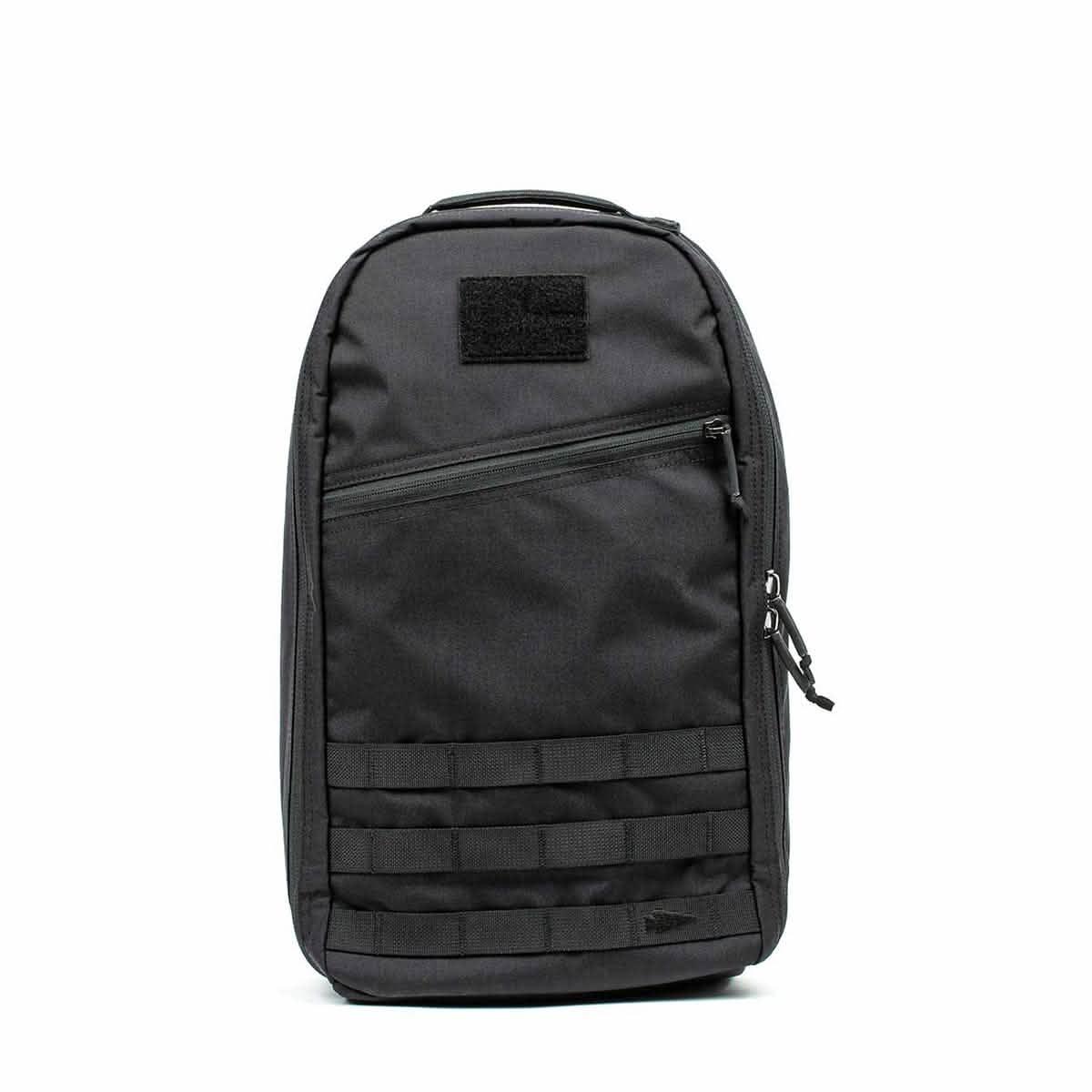 Black tactical GORUCK rucksack with front diagonal zip pocket and MOLLE webbing on white background