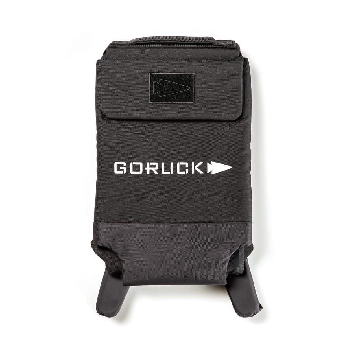 The Ruck Plate Carrier 3.0 from GORUCK is a black backpack made from durable 1000D CORDURA material, featuring a top handle and two shoulder straps. It includes a Velcro patch area, ergonomic lumbar support for added comfort, and an arrow-themed logo on the front.
