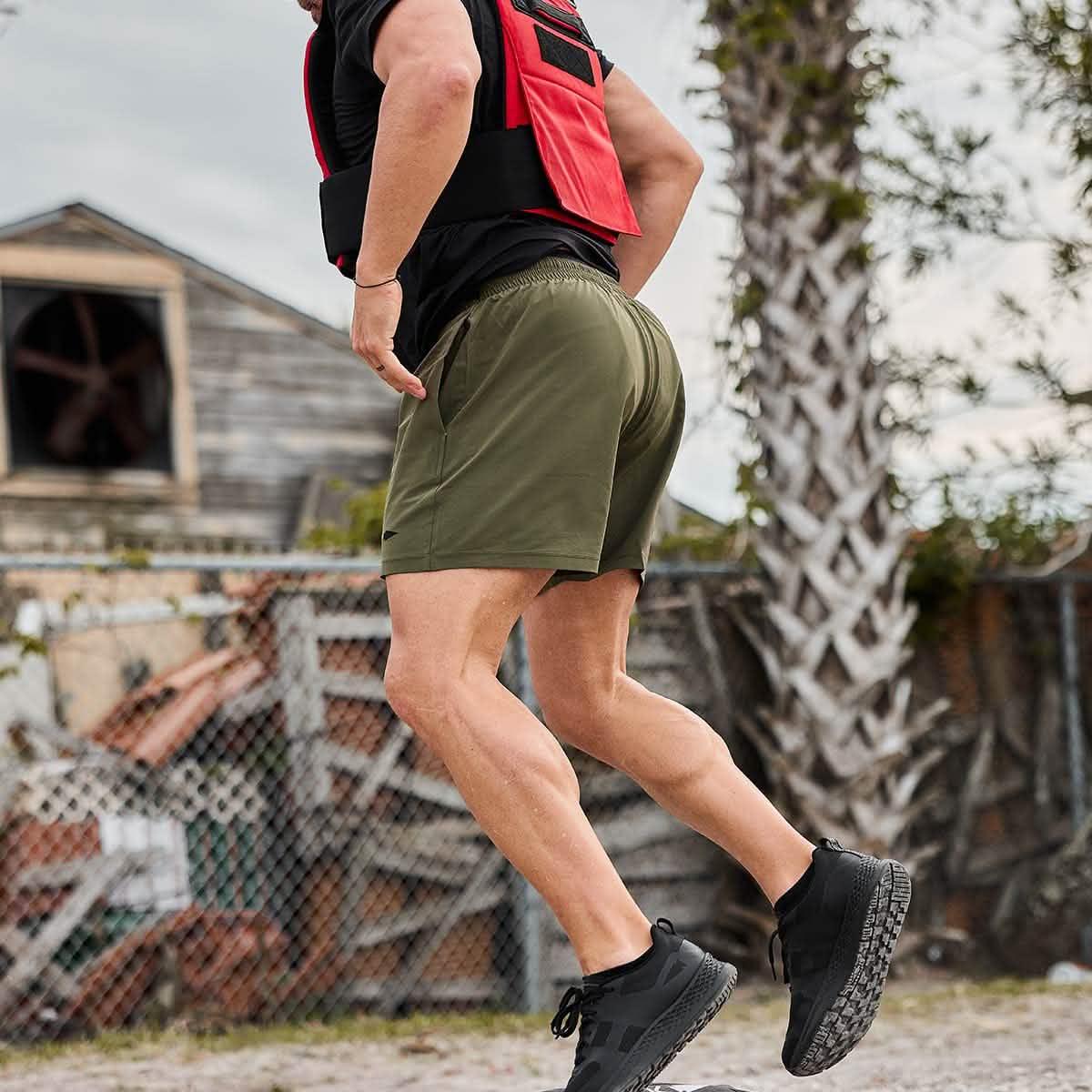 Man running outdoors wearing GORUCK olive green athletic shorts and black shoes