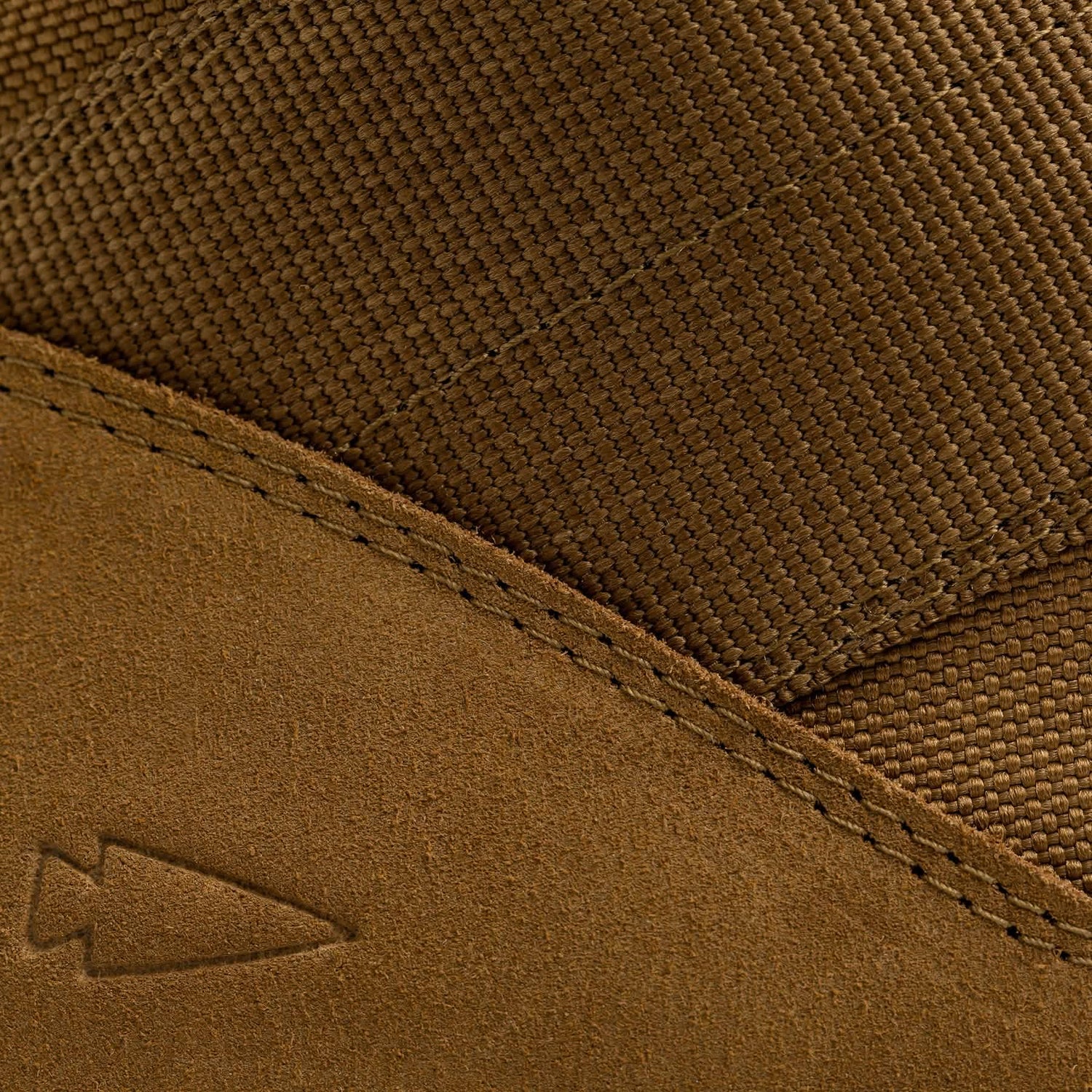 Close-up of a GORUCK MACV-2 high-top in coyote suede showing off textured fabric and visible stitching, evocative of classic jungle boots. A small embossed arrow logo on the suede adds a unique touch to its rugged style.