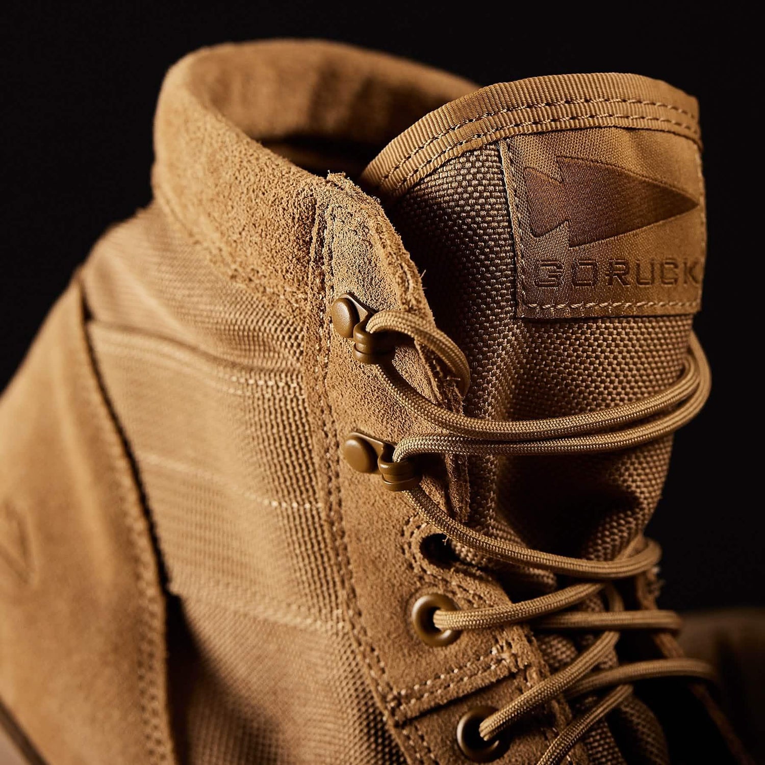 Close-up of tan GORUCK tactical rucking boot with durable suede and nylon upper against black background
