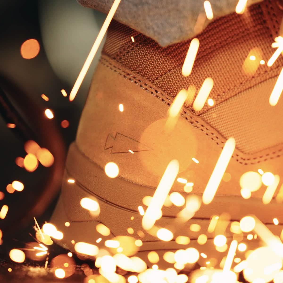 GORUCK tan rucking boot close-up with sparks flying, durable footwear for tough conditions