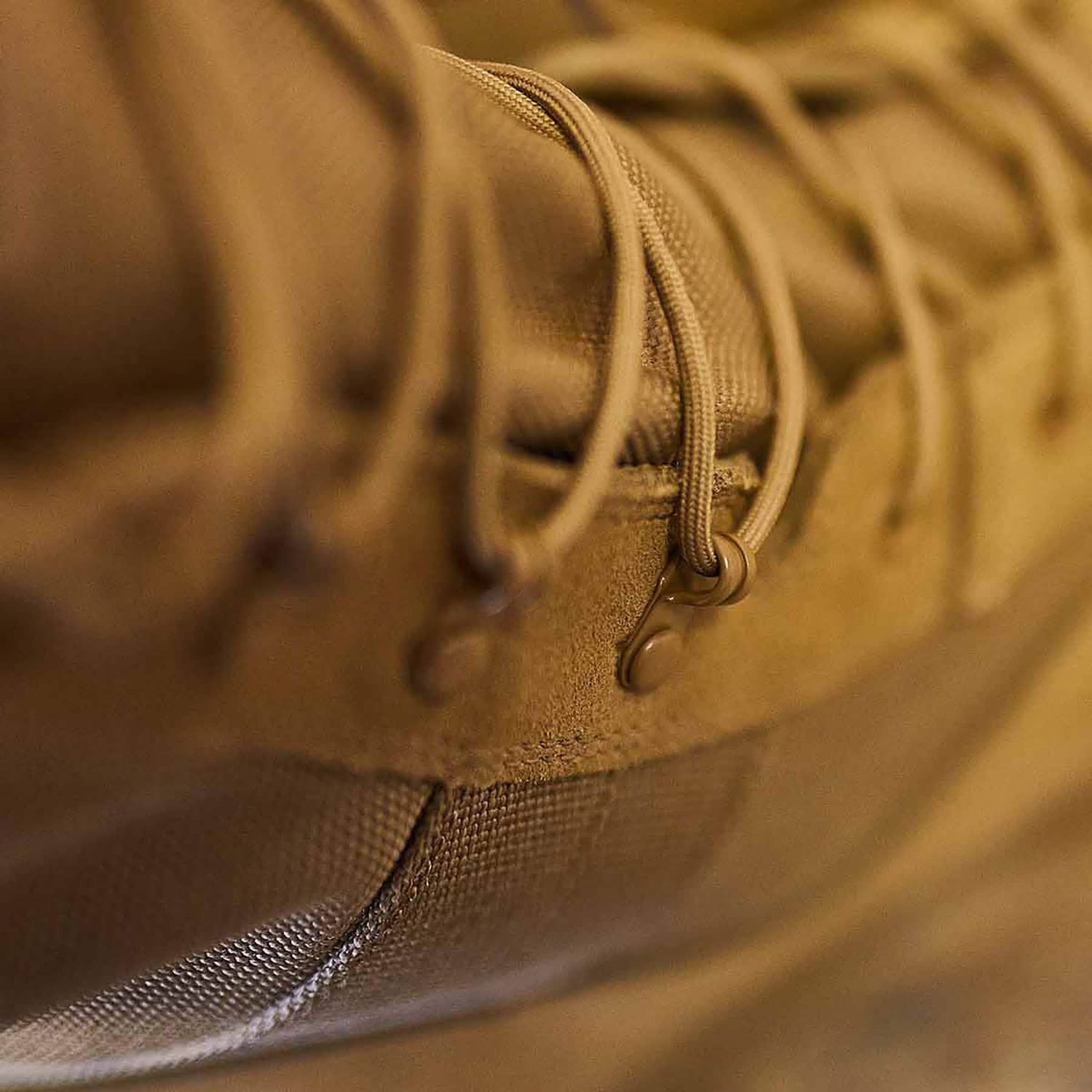 Close-up of a tan MACV-1 Hi-Speed - High Top hiking boot by GORUCK, focusing on the laces and eyelets. The texture of the fabric and leather is visible, highlighting the rugged design of these lightweight boots, making them AR670-1 compliant for both durability and comfort on any adventure.