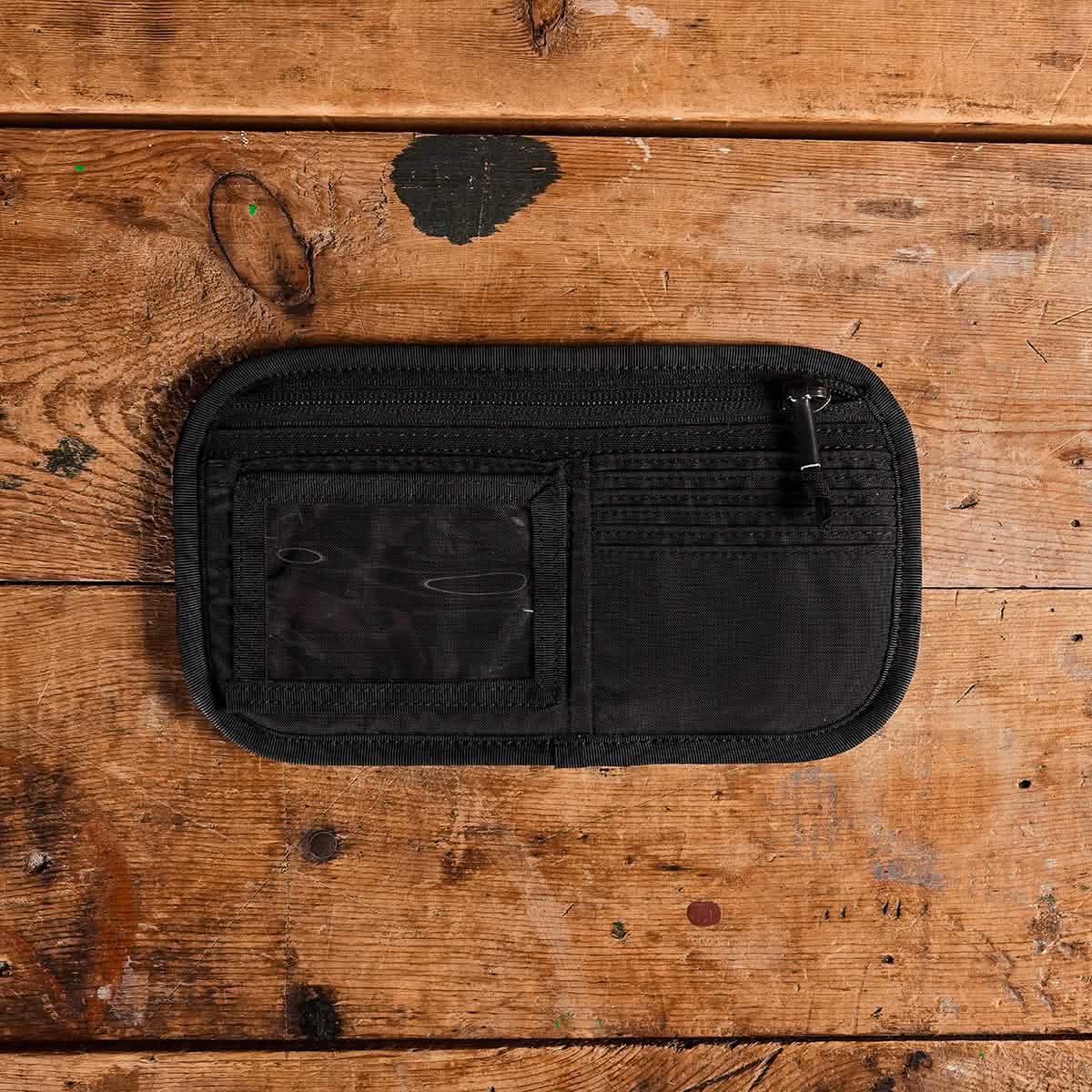 Black nylon admin panel with ID card holder and zippered pocket on wooden surface, GORUCK gear