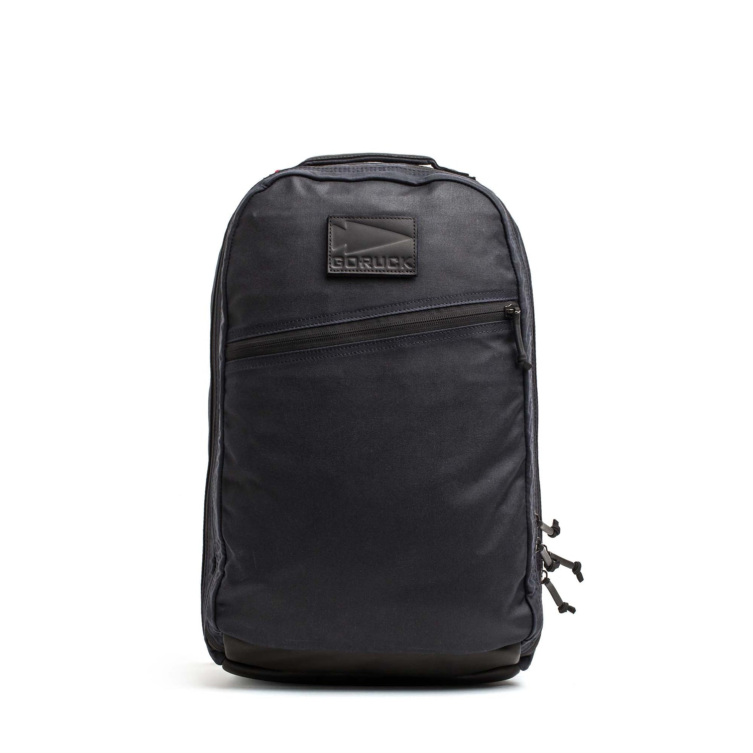 The Double Compartment Bullet Ruck - Heritage Waxed Canvas - 18L is a black backpack with a front zipper pocket and GORUCK logo patch, ideal for daily use or travel as a reliable rucksack.