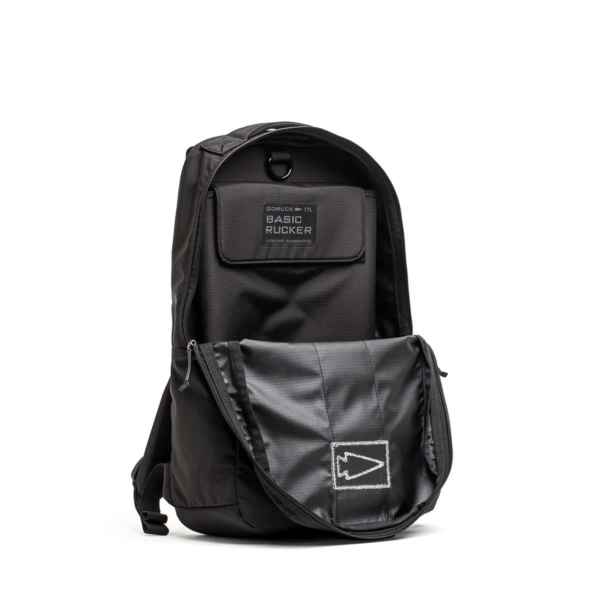 Black Basic Rucker® backpack with an open front pocket, displaying a patch labeled