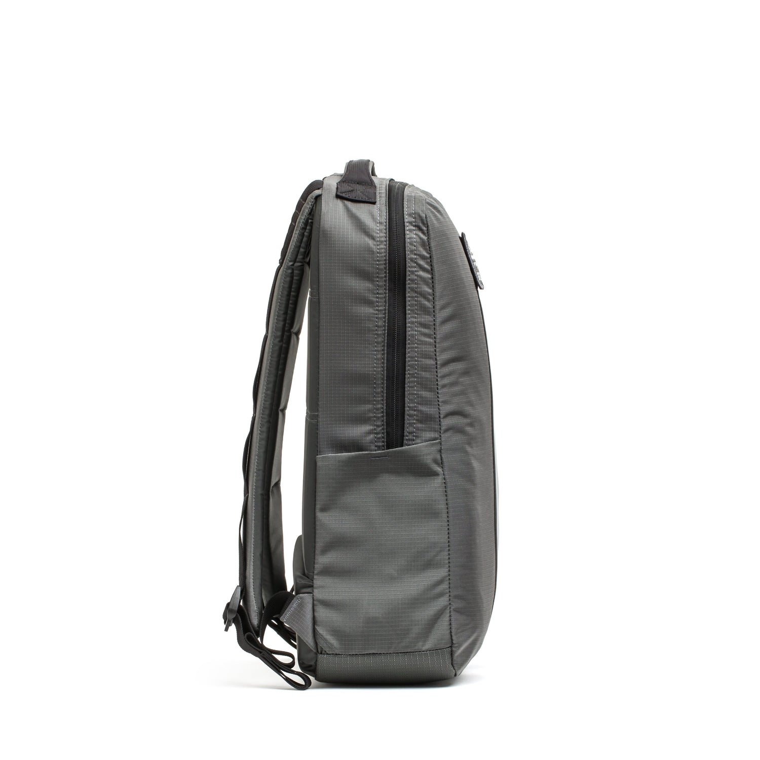 The Basic Rucker® in gray is shown from the side, featuring padded straps and a front zip pocket for convenient storage.