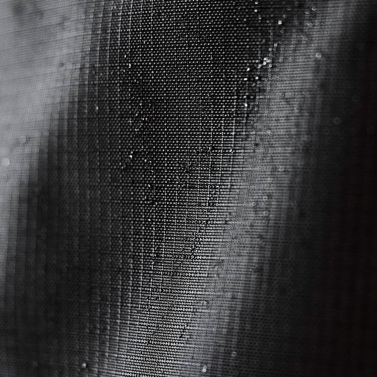 Close-up of black GR0 - Ripstop ROBIC® fabric with water droplets, highlighting the durable, water-resistant material used in minimalist everyday carry and backpacks.