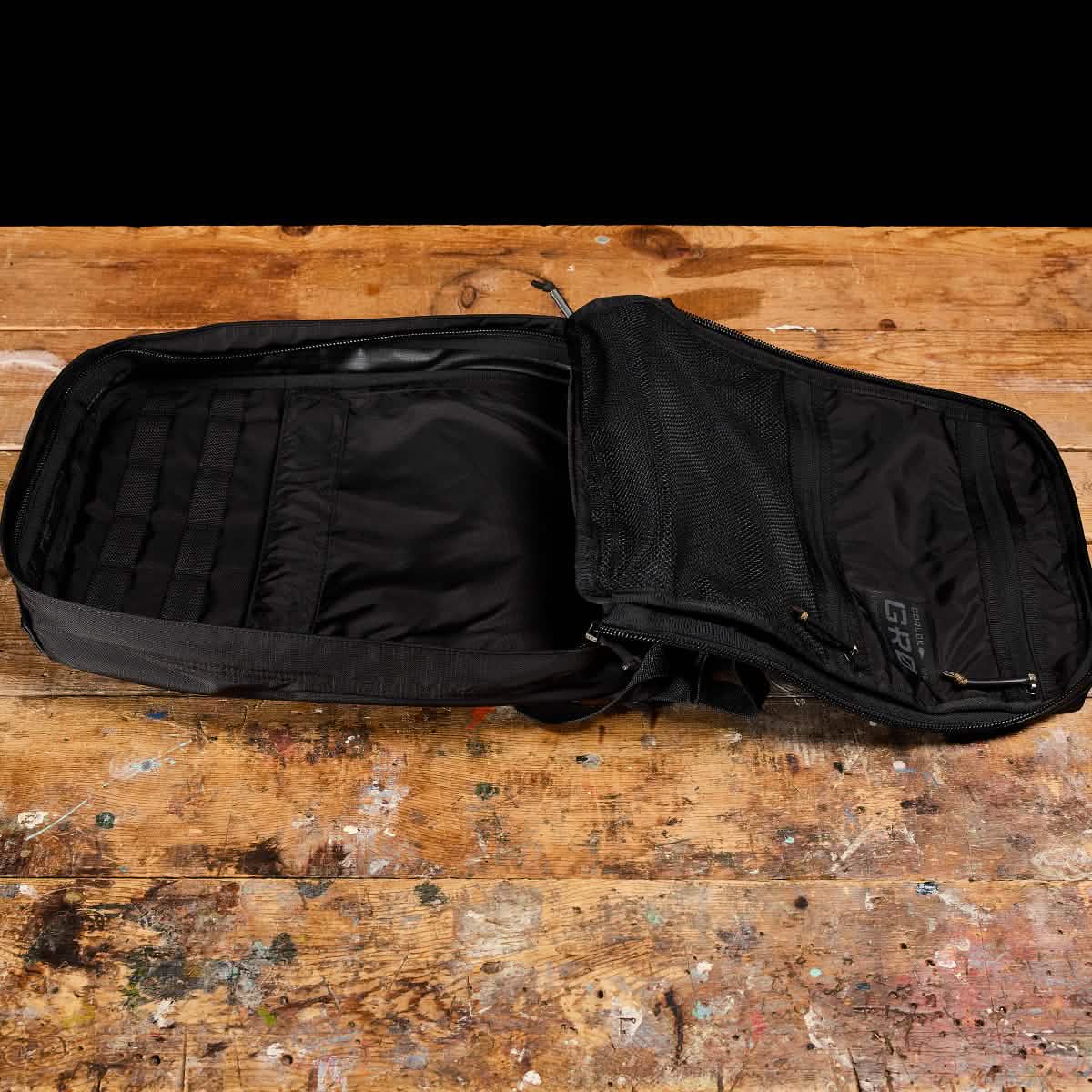 The GR0 - Ripstop ROBIC® rucksack with mesh pockets rests on a worn wooden surface, ideal for minimalist everyday carry.