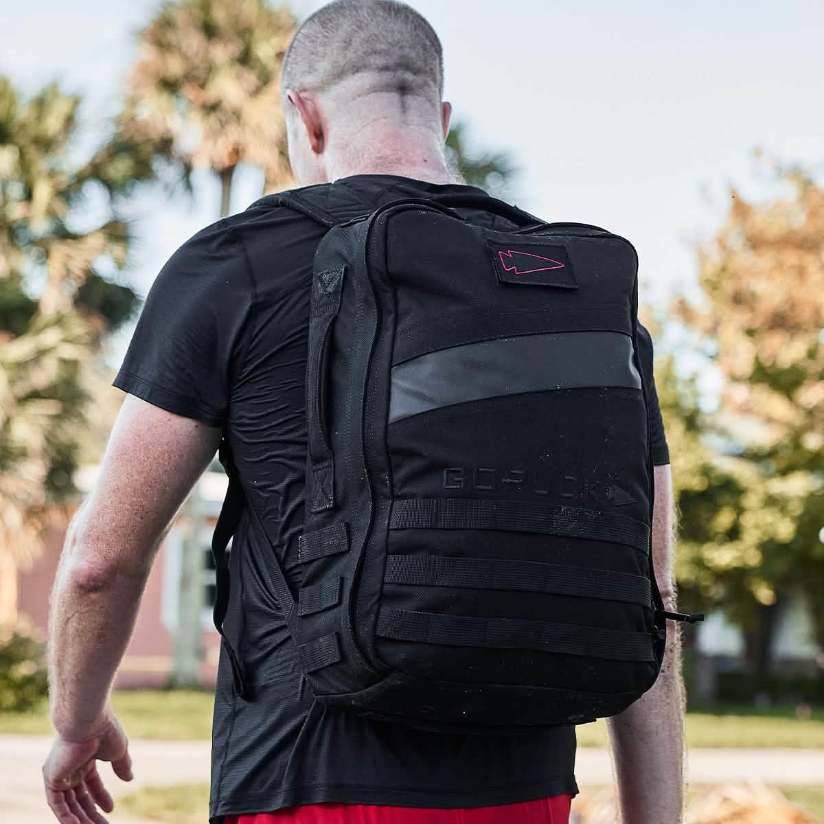 Person wearing a GORUCK Blackout 20L backpack outdoors, showcasing durable rucking gear.