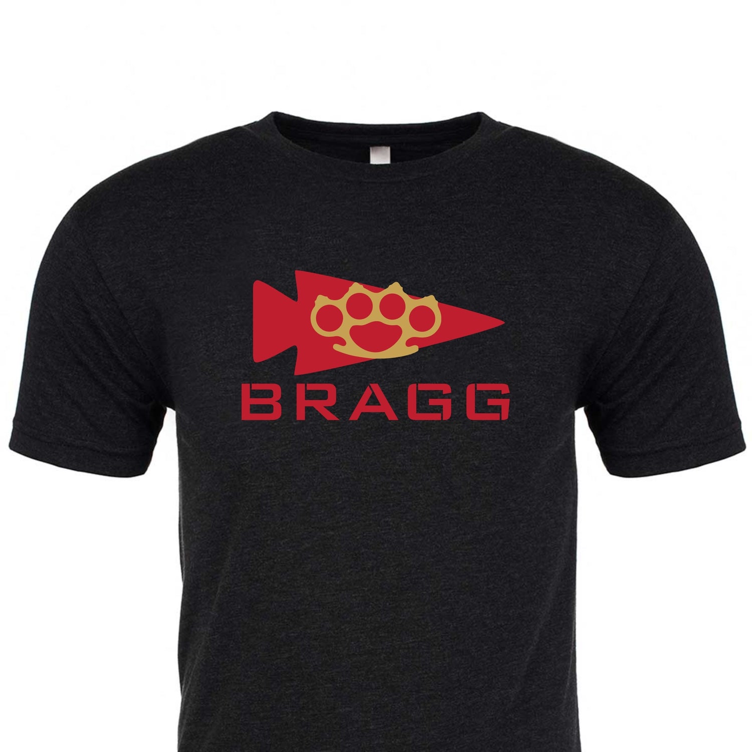 The Bragg GORUCK Challenge Tee - Tri-Blend, created by GORUCK, is a black T-shirt made from high-quality tri-blend fabric. It showcases an eye-catching red arrowhead and paw print design above the word