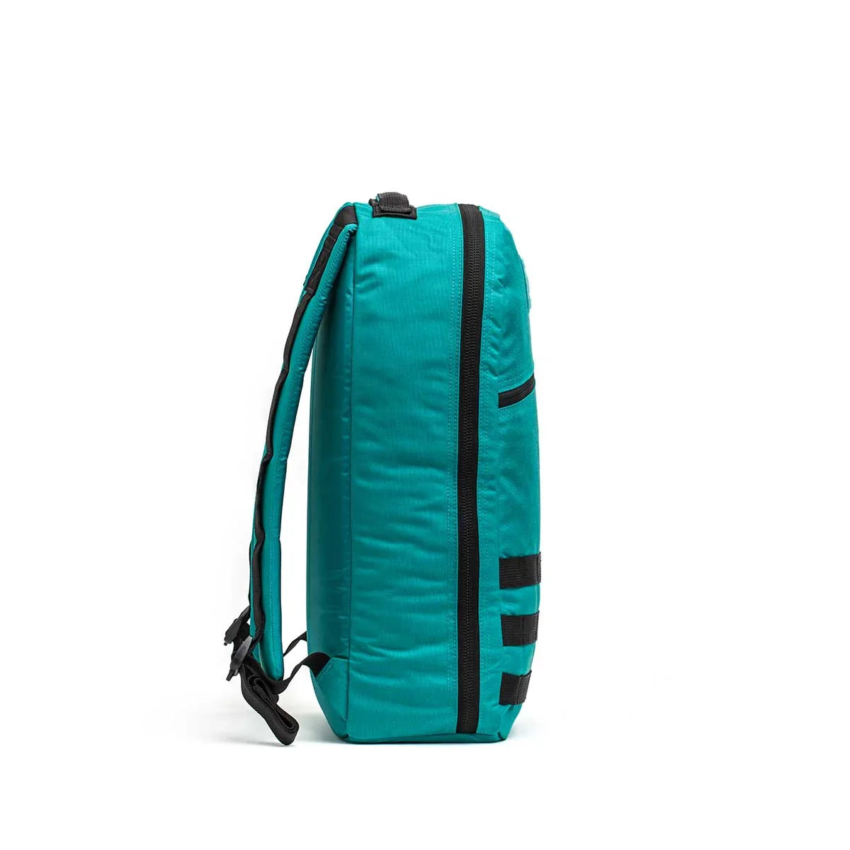 Side view of GORUCK Bullet 15L teal rucksack with black zippers and straps on white background