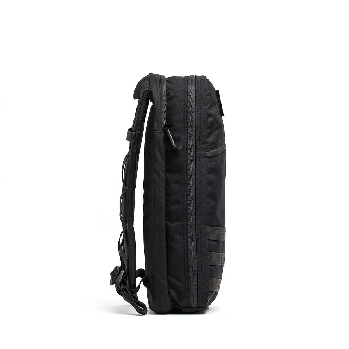 Side view of a compact black GORUCK Bullet Ruck 10L backpack with padded straps and exterior MOLLE webbing