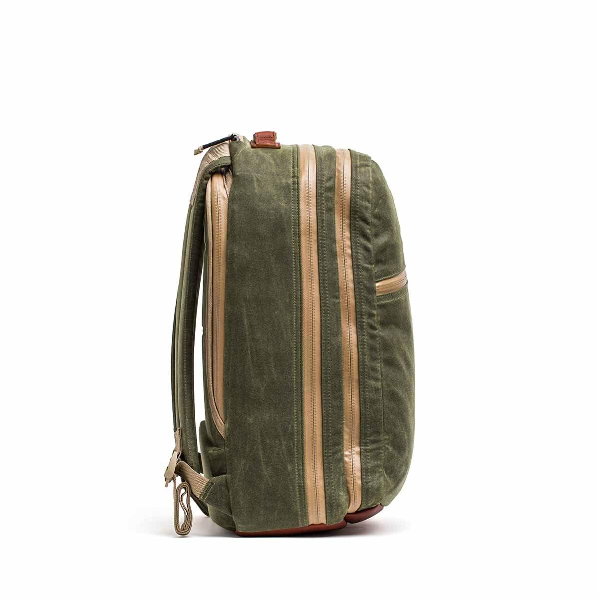 Side view of olive green GORUCK Bullet 18L backpack with tan waterproof zippers against white background