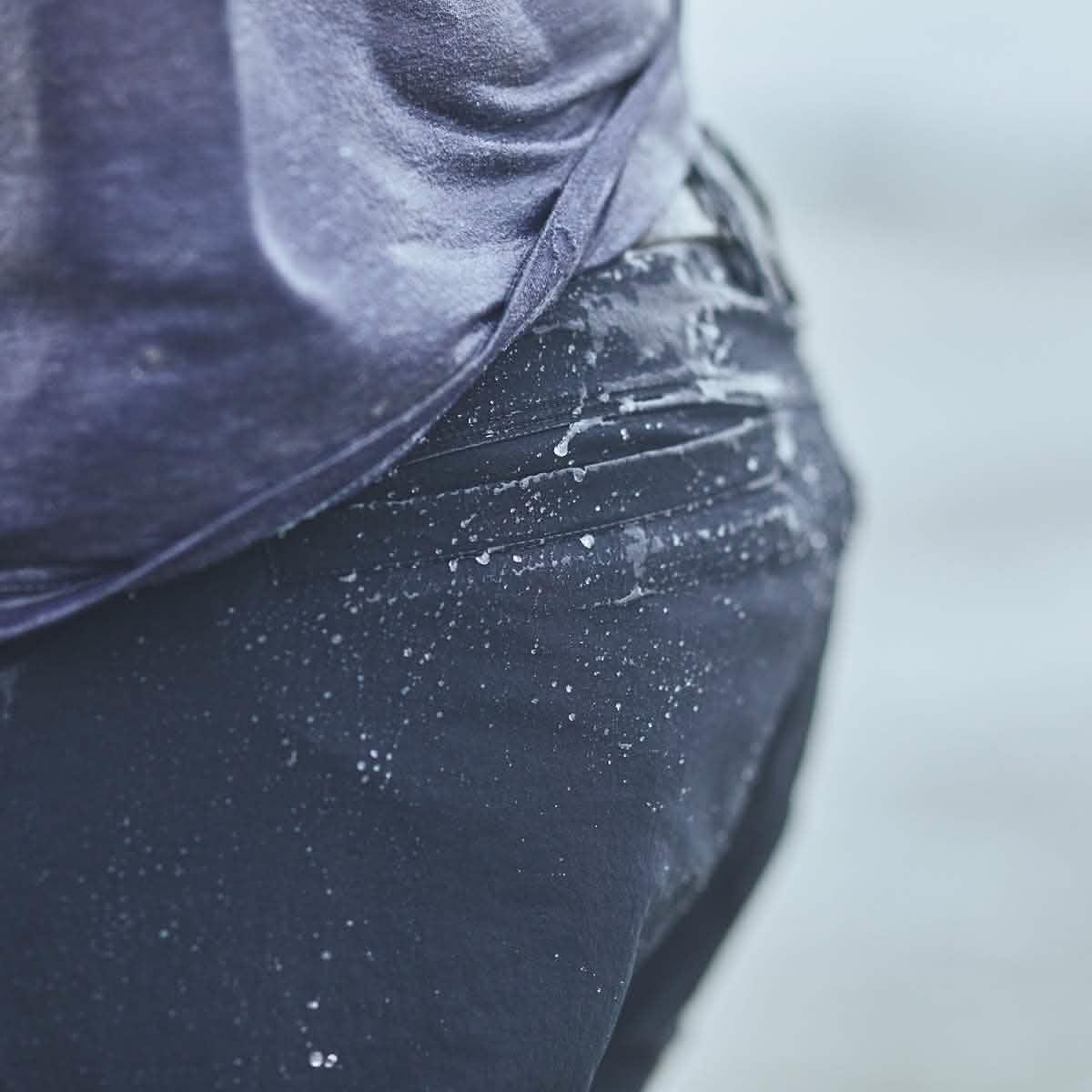 Close-up of a person wearing wet Navy GORUCK Challenge shorts with water droplets on fabric