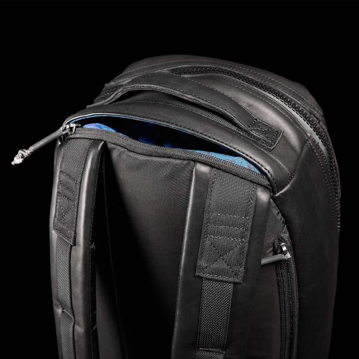 Close-up of black GORUCK tactical rucksack with padded straps and partially open zipper revealing blue interior