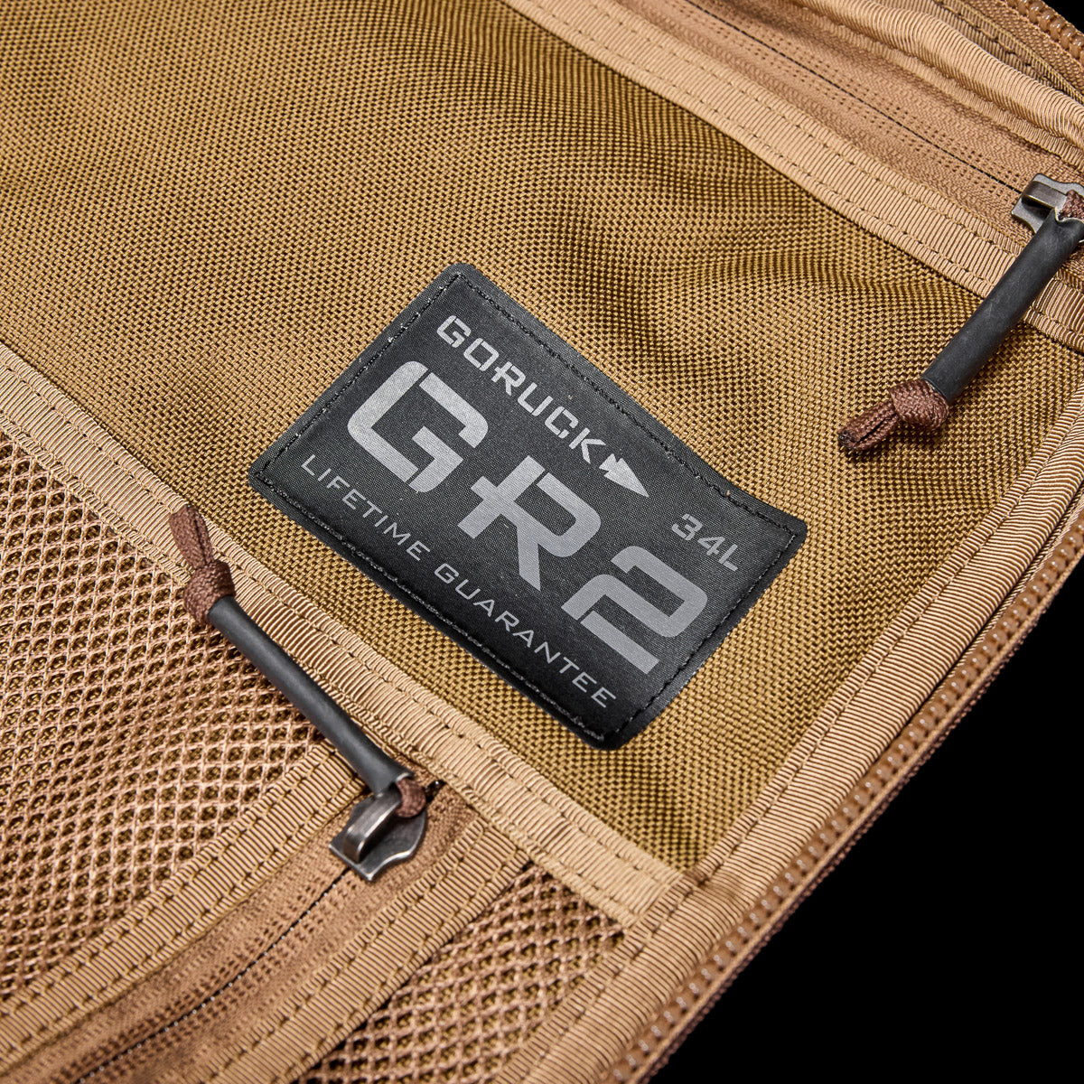 Close-up of tan GORUCK GR2 34L backpack label and mesh pocket with zipper, durable rucking gear