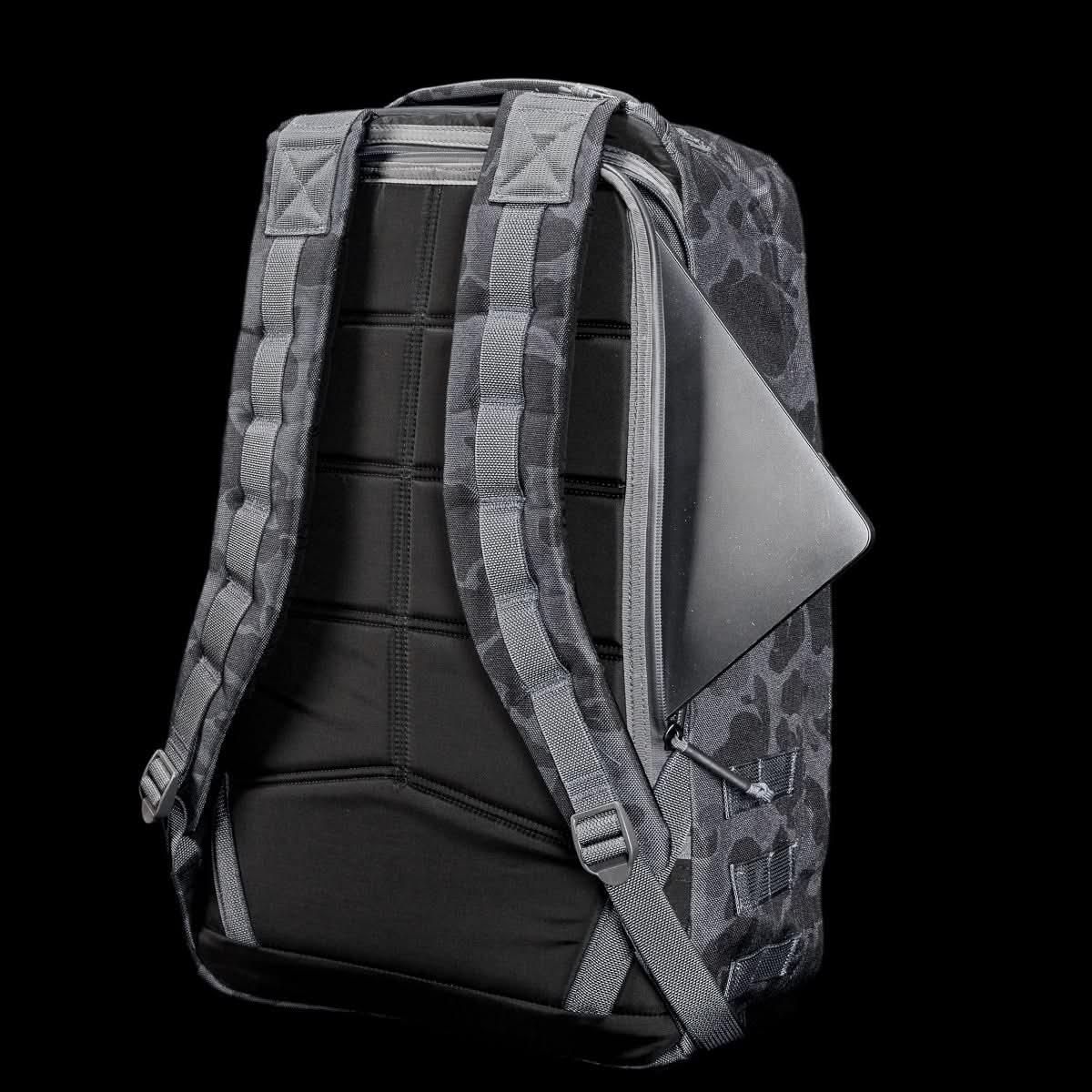 GORUCK backpack in black Frogskin camo with padded straps and a laptop partially inserted in a side zipper pocket