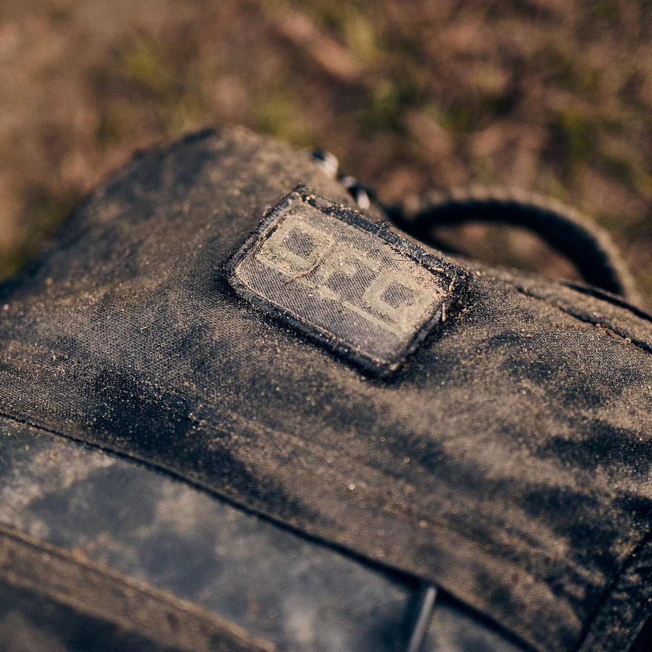 A close-up of a dirt-covered fabric bag with a worn