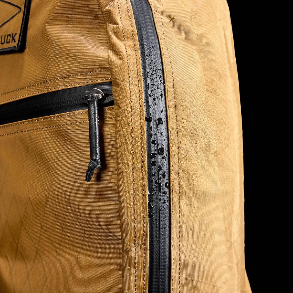 GORUCK tan rucksack close-up, showing water-resistant fabric and zipper detail