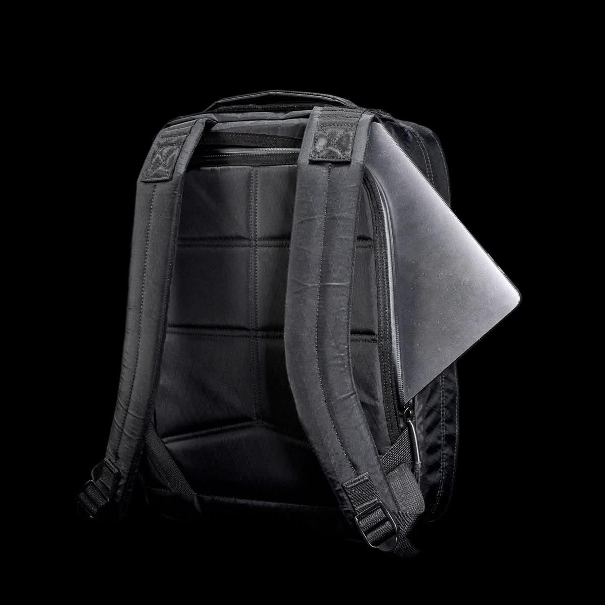 GORUCK black rucksack with padded straps, laptop in back compartment, on black background