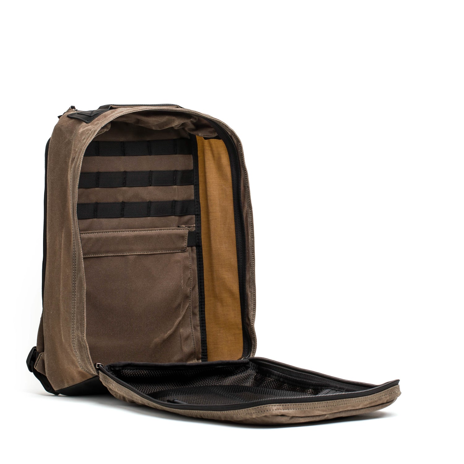 The GR1 USA - Heritage Rucksack by GORUCK, in brown, features a fully open main compartment that unveils several internal pockets and compartments for organization. Its lining is a contrasting yellow-brown hue, adding to its minimalist and modern appeal.