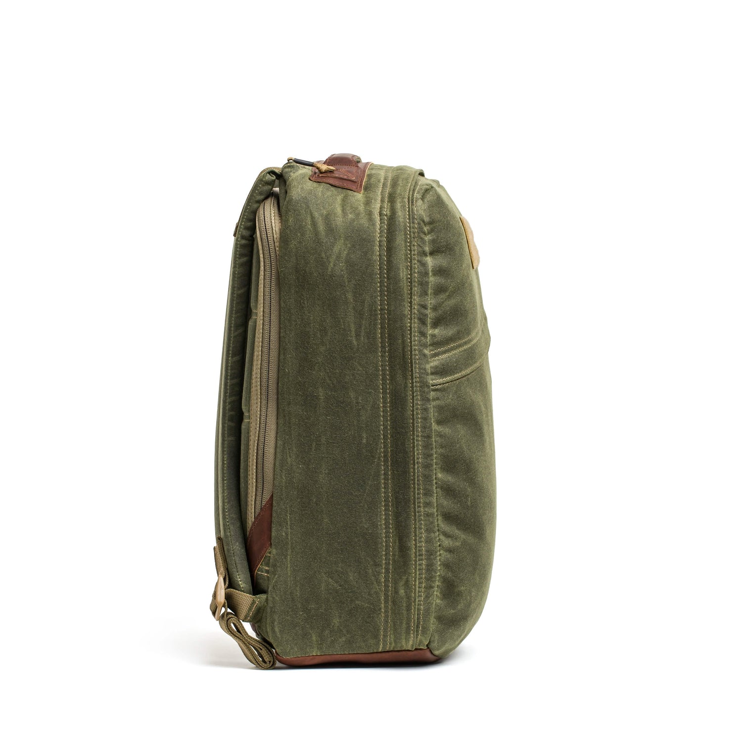 Side view of olive green Heritage rucksack with rugged canvas material and tan accents on white background