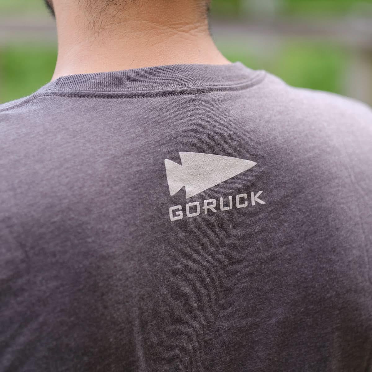 GORUCK logo printed on the back of a gray t-shirt, outdoor setting