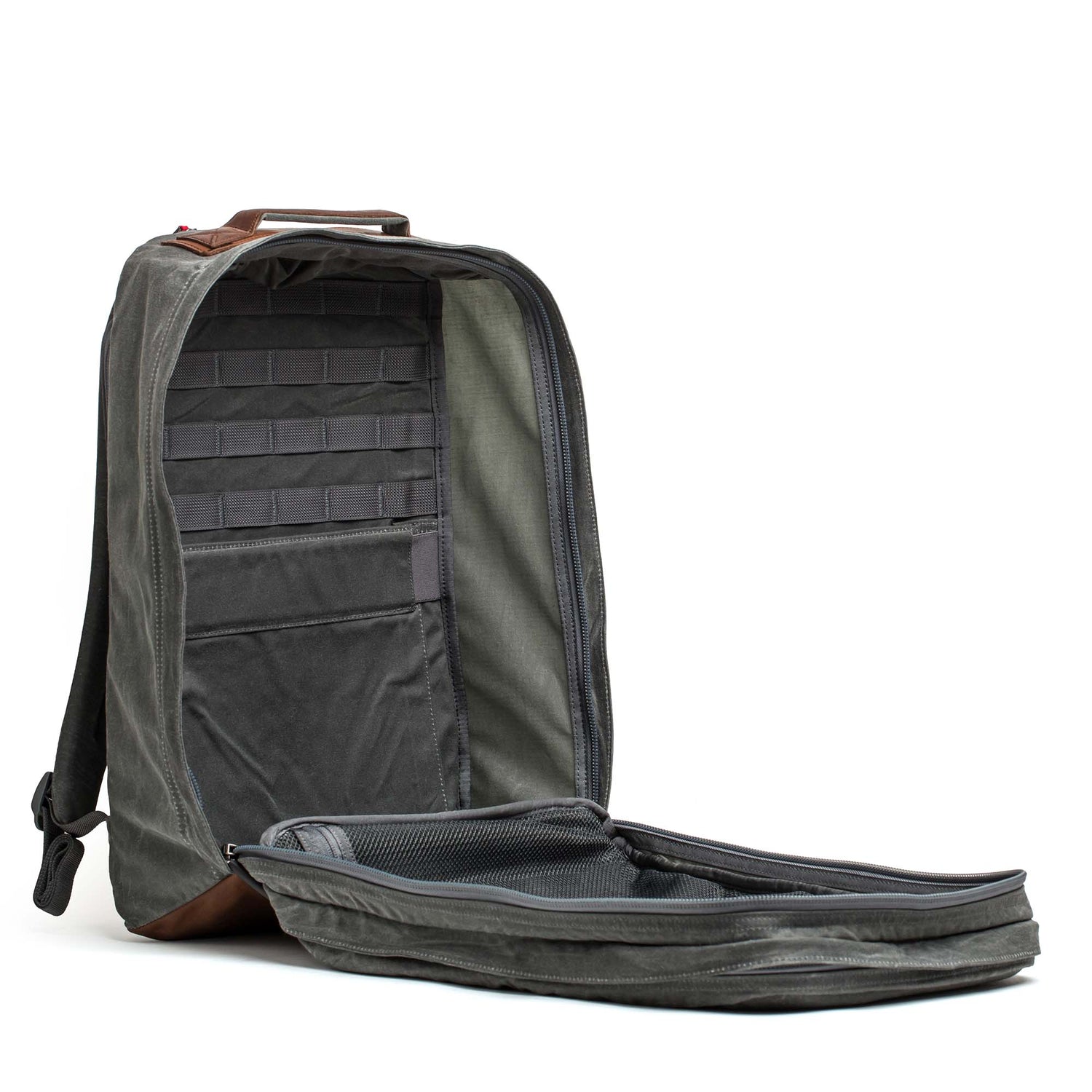 The GR2 - Heritage Waxed Canvas backpack in gray is open, displaying an organized interior with multiple pockets and compartments.